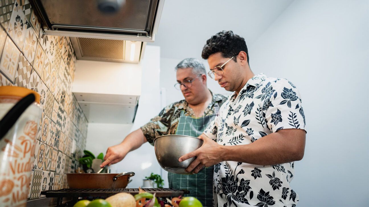 Two people cooking food together.