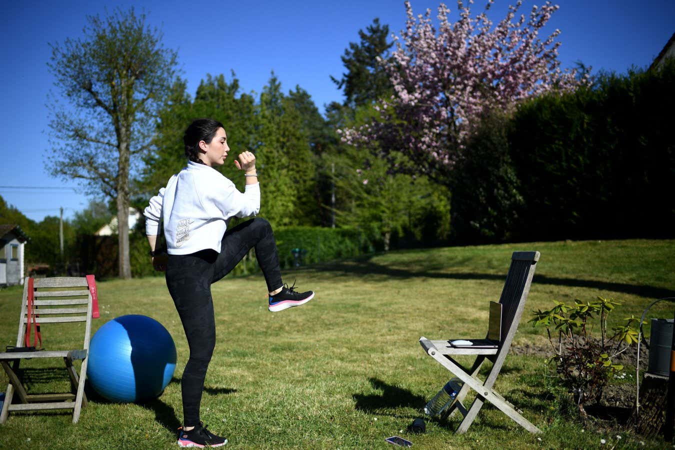 TOPSHOT - Fitness coach Gabrielle Friscira gives a lesson by videoconference in Saint-Remy-lHonore, west of Paris, on April 15, 2020, on the 30th day of a strict lockdown in France aimed at curbing the spread of the COVID-19 pandemic, caused by the novel coronavirus. (Photo by FRANCK FIFE / AFP) (Photo by FRANCK FIFE/AFP via Getty Images)