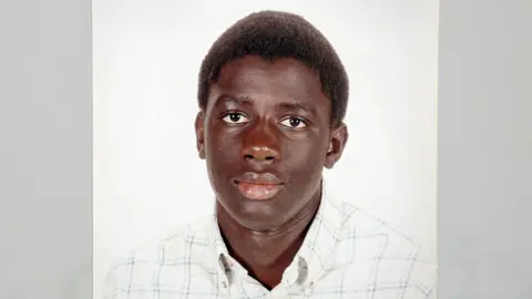 FAMILY HANDOUT A family photo of Valdo Calocane as a teenager, wearing a white checked shirt with a button-down collar and looking directly at the camera