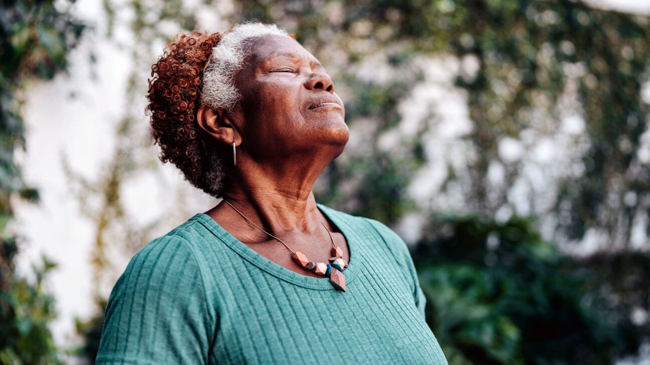 Older female takes a deep breath outdoors