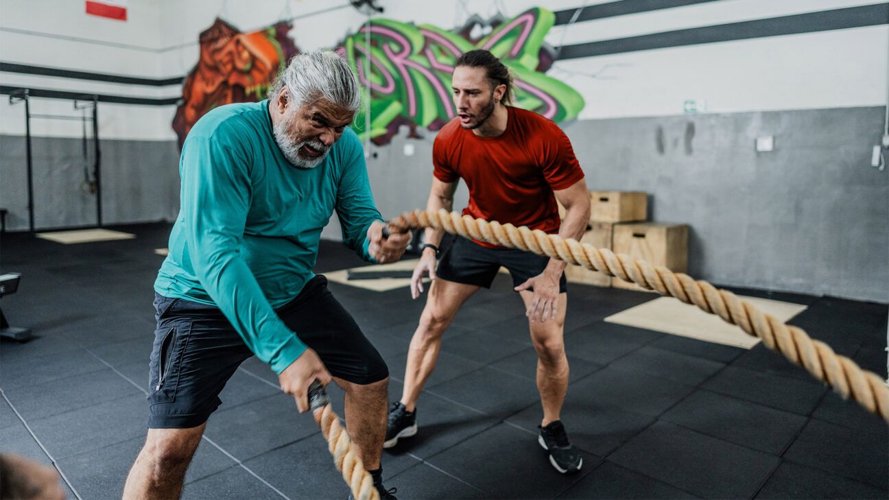 Older male exercising with battle ropes