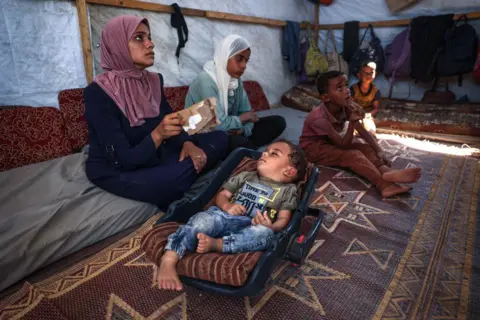 AFP Picture of a young boy who contracted polio, alongside his family 