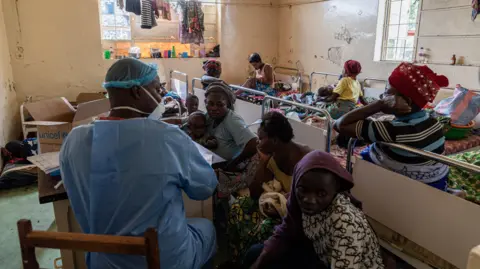 Glody Murhabazi Women and children sit waiting to see a doctor