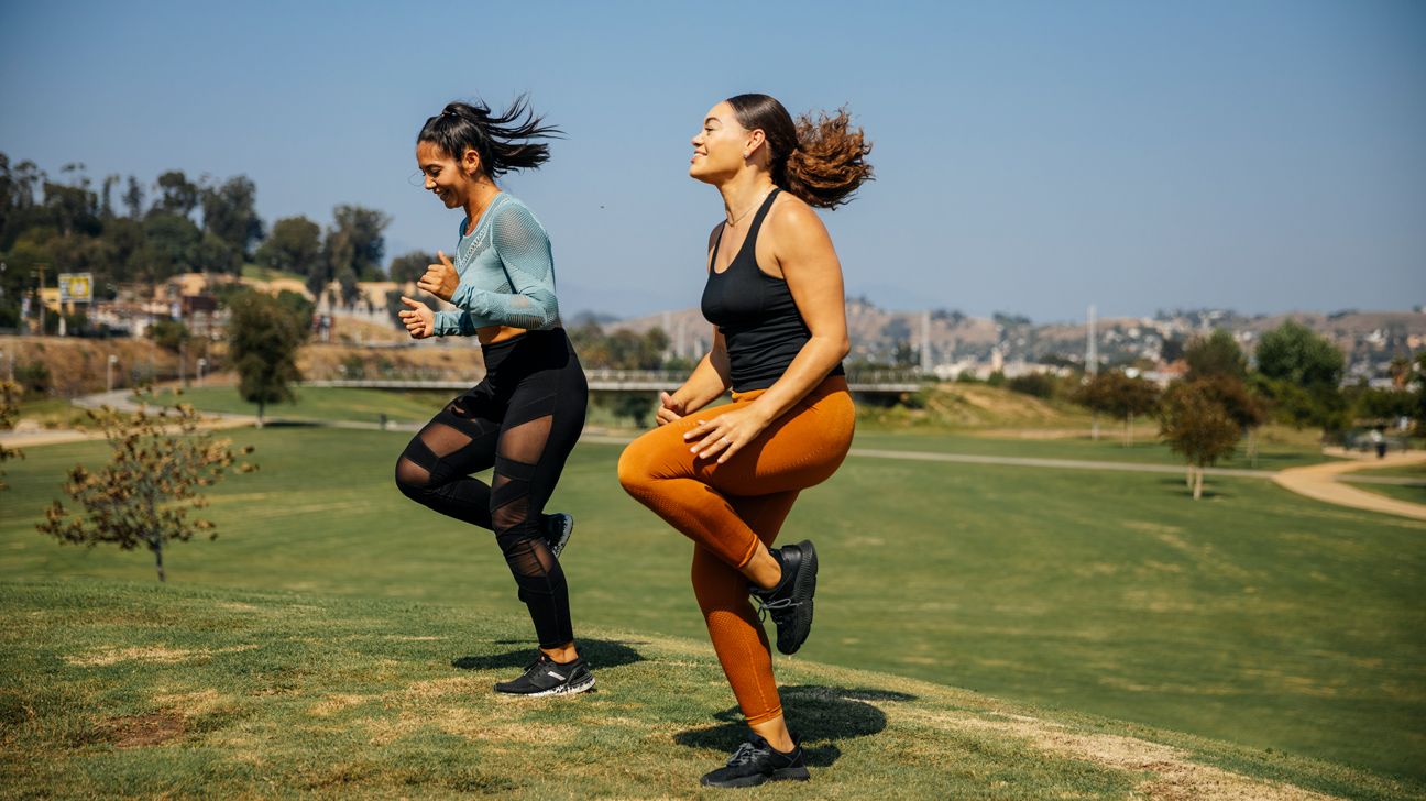 Two females doing cardio fitness outdoors