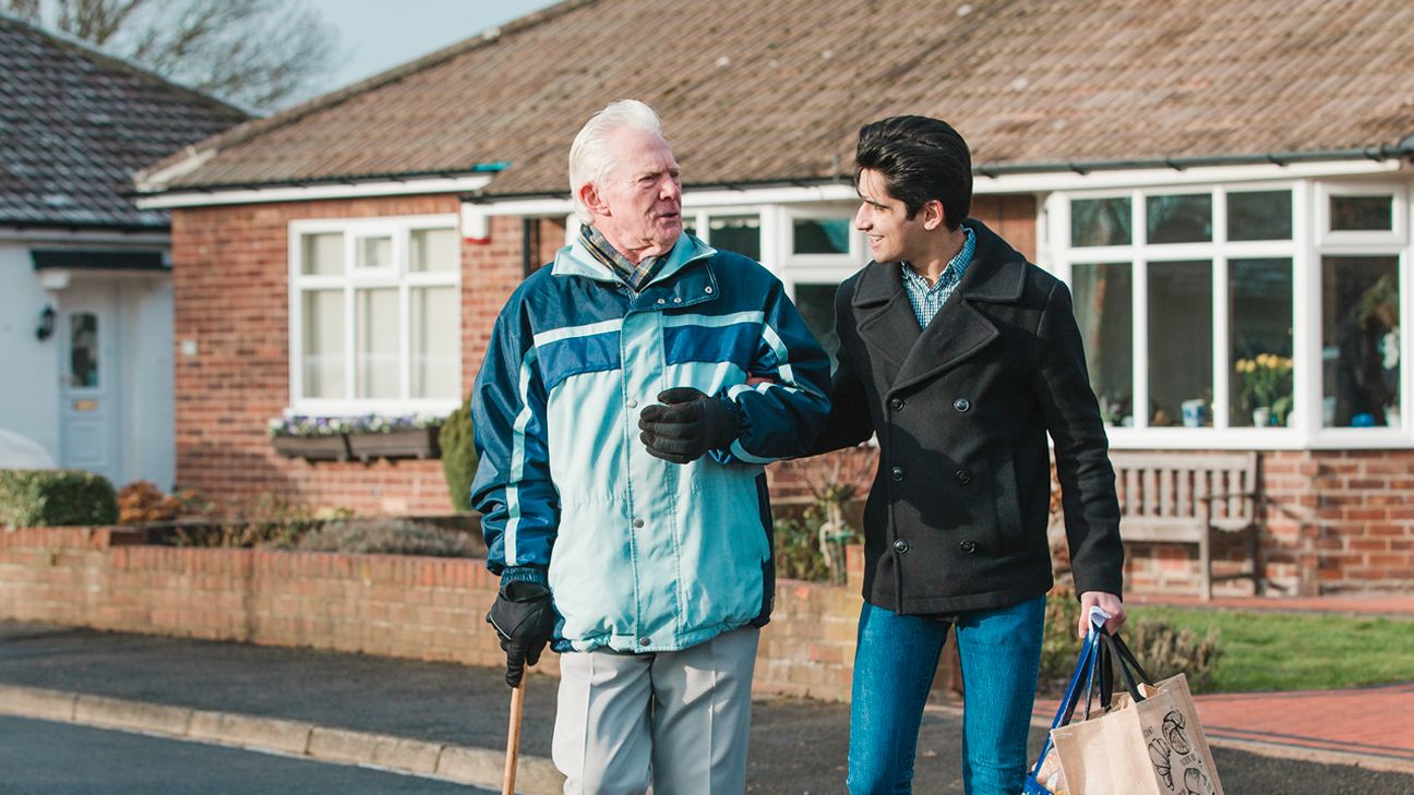 Teen male walking with grandparent.