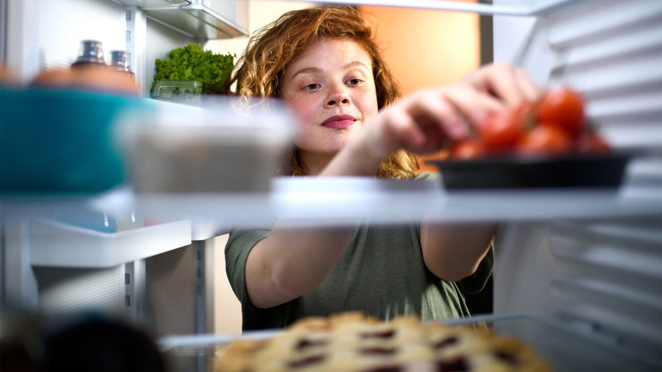 Female decorating the inside of her refrigerator.