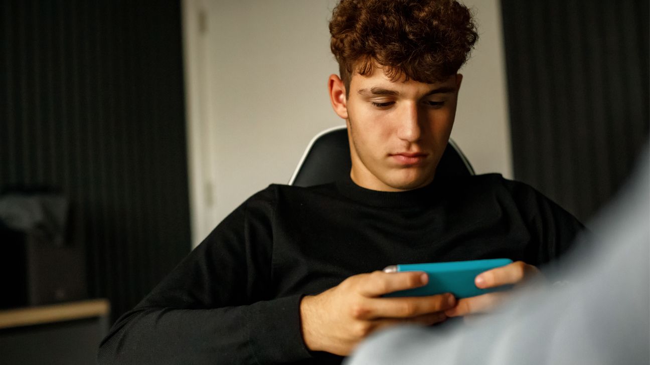 Male teen using smartphone.