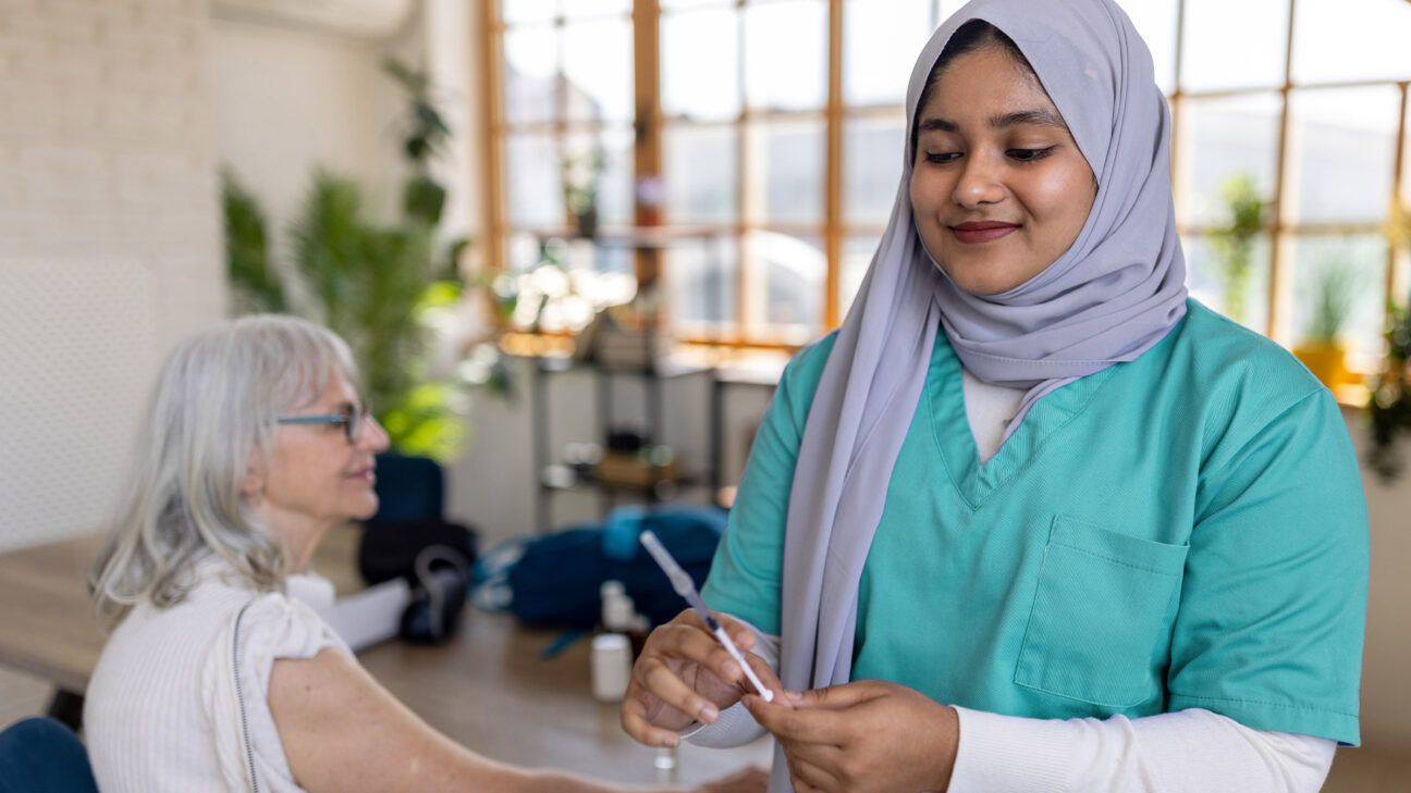 Female nurse prepares a flu shot for a patient.