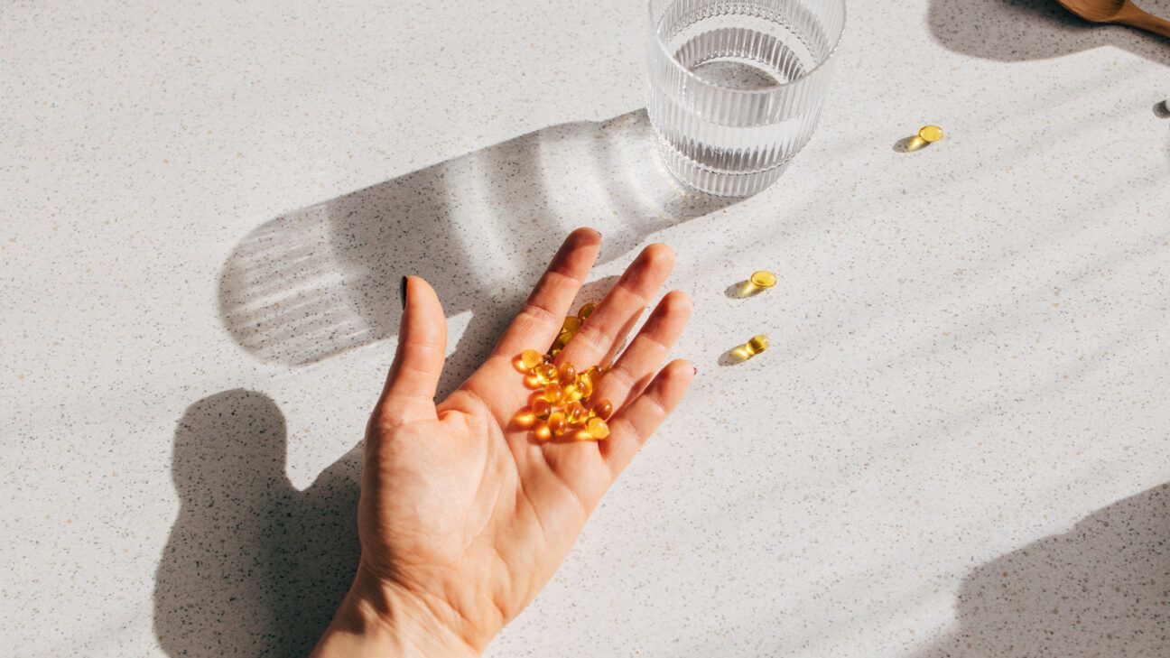 Vitamin d supplement capsules in a person's hand.