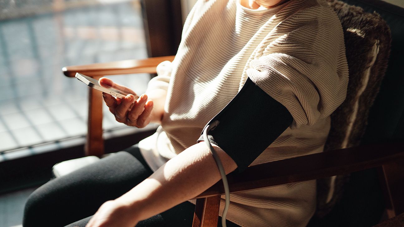 Female checks blood pressure at home