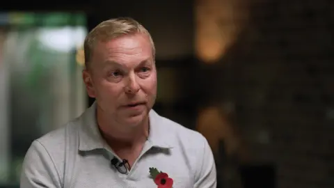 BBC Sir Chris Hoy wearing a grey polo shirt and poppy speaks to the BBC