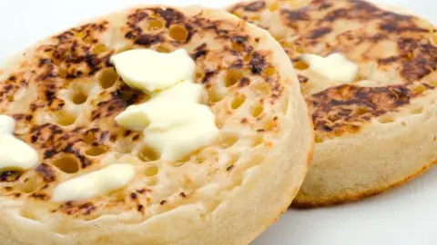 Getty/clubfoto A close-up of two crumpets covered in melted butter