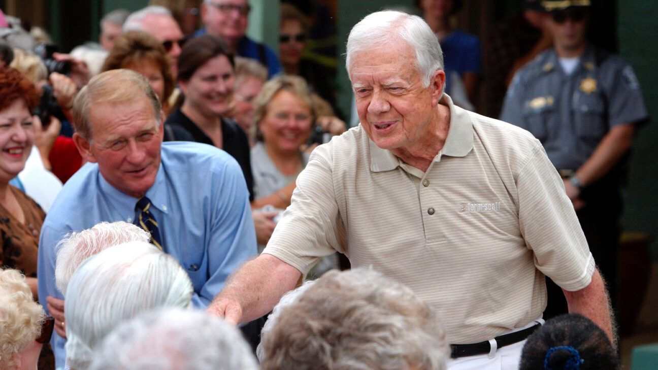 Former US president Jimmy Carter shakes hands with people at an event