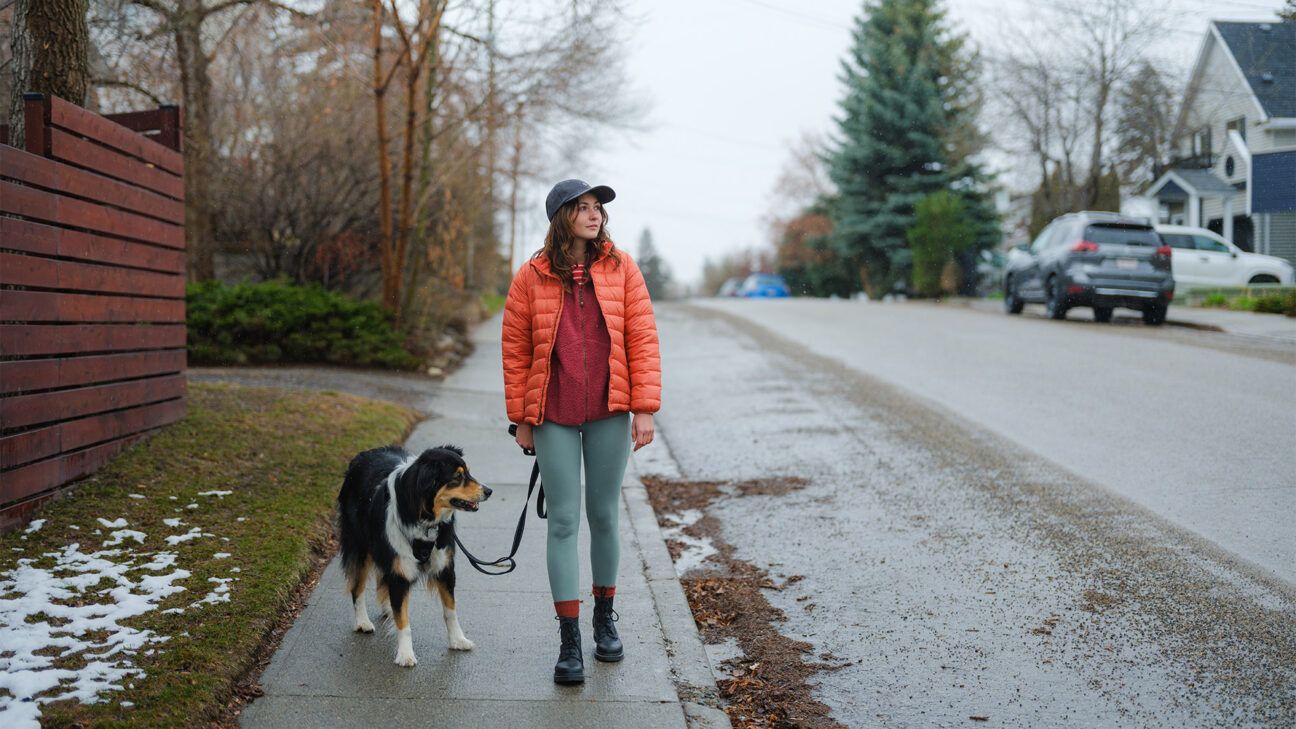 Female walks outside with dog