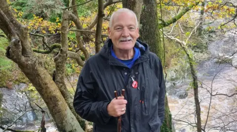 Family handout Paul Nelson stops for a photo in the woods while out for a walk