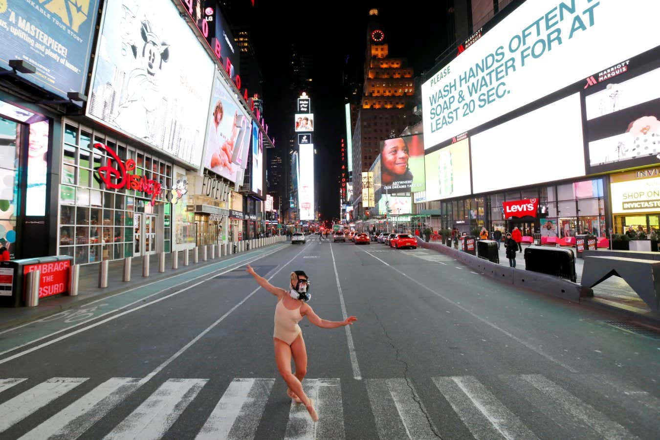 Ballerina Ashlee Montague wears a gas mask while she dances in Times Square, New York City, amid covid-19 restrictions on 18 March 2020