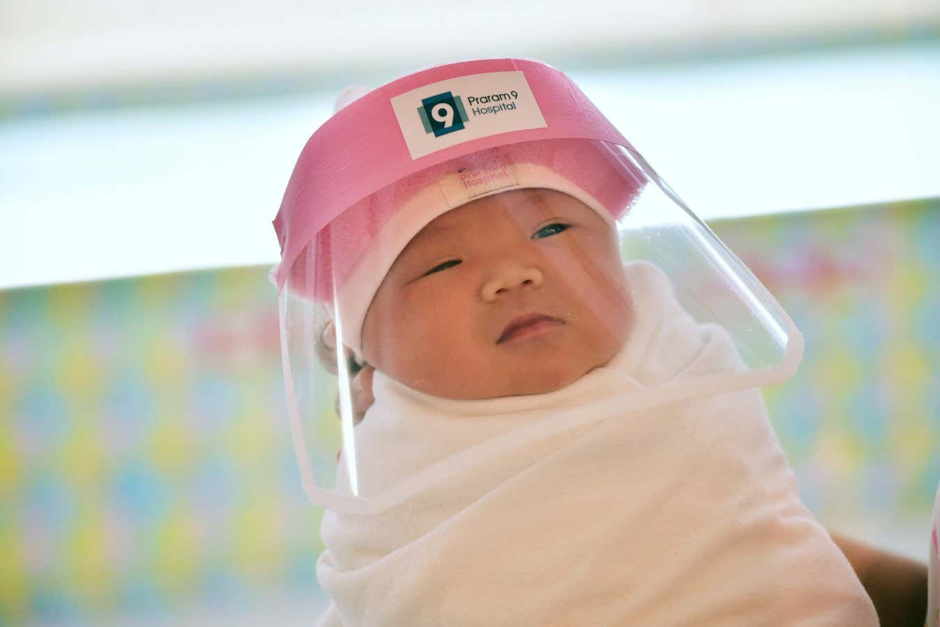 A newborn wearing a face shield at Praram 9 Hospital in Bangkok, Thailand, on 9 April 2020