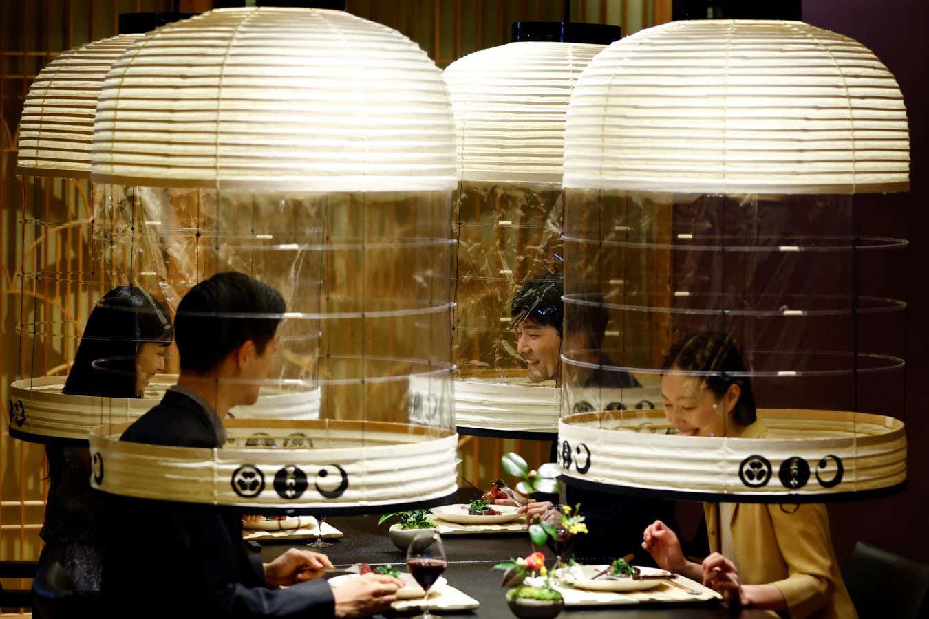 Hotel staff demonstrate how to eat within lanterns to ward off covid-19 in Tokyo, Japan, in February 2022