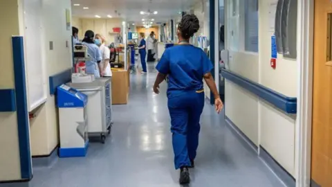 PA Media Hospital staff walking through a ward