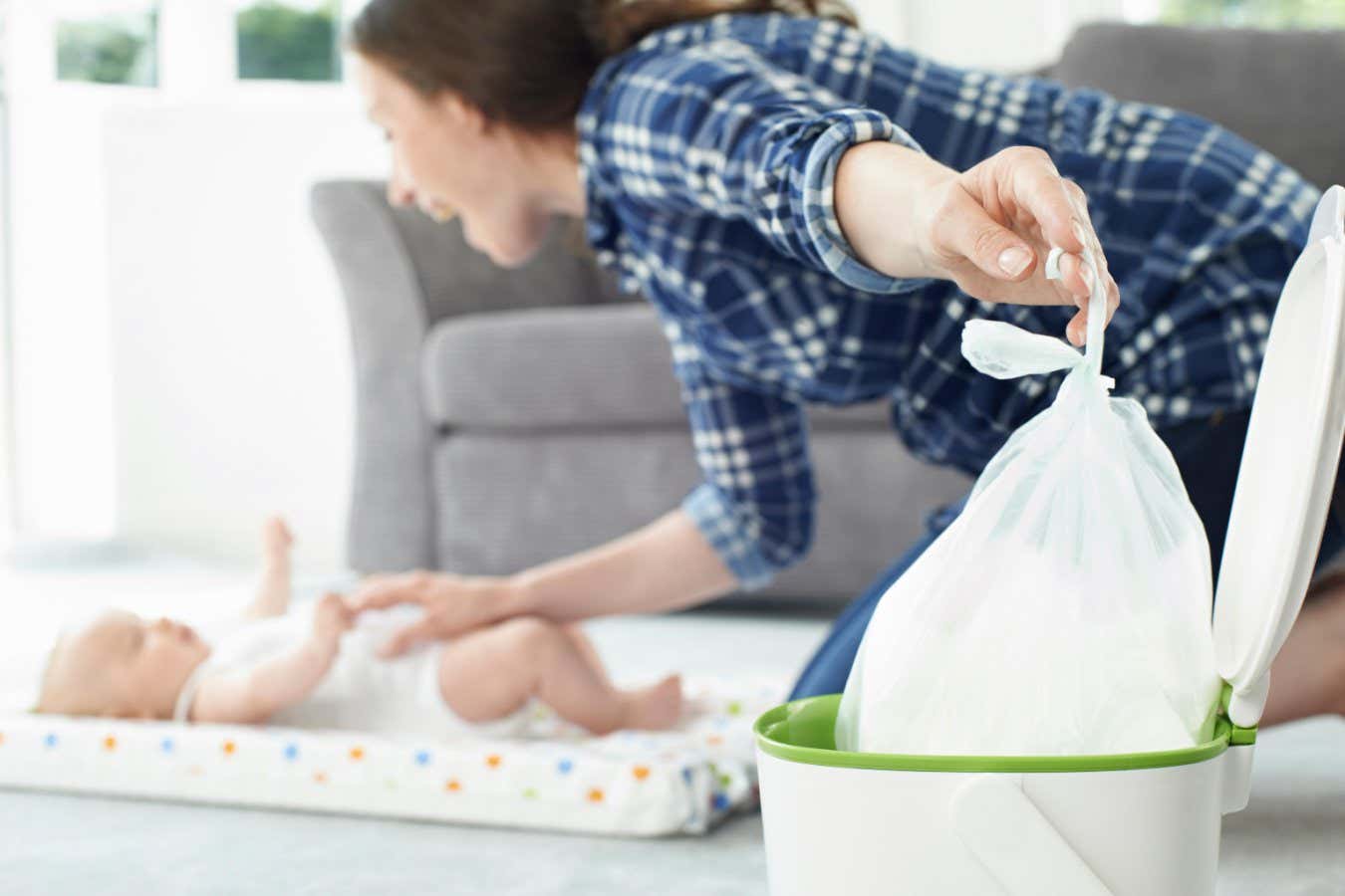 GM7DEY Mother Disposing Of Baby Nappy In Bin