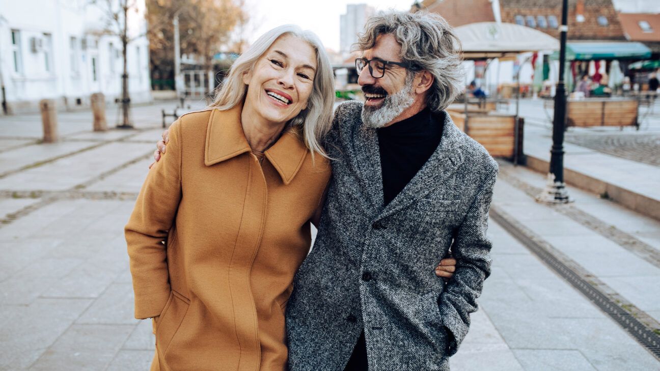 Older couple walking outside smiling