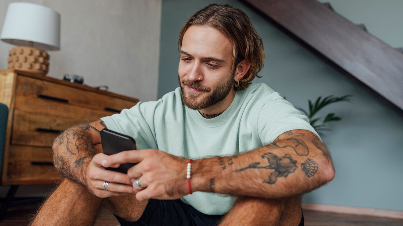 Male sitting on floor with phone