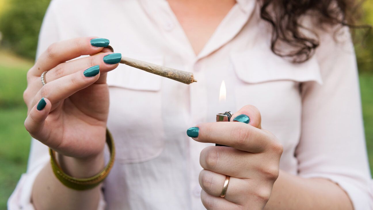 Female lights a cannabis joint