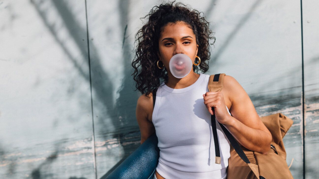 Female chewing gum and blowing bubble