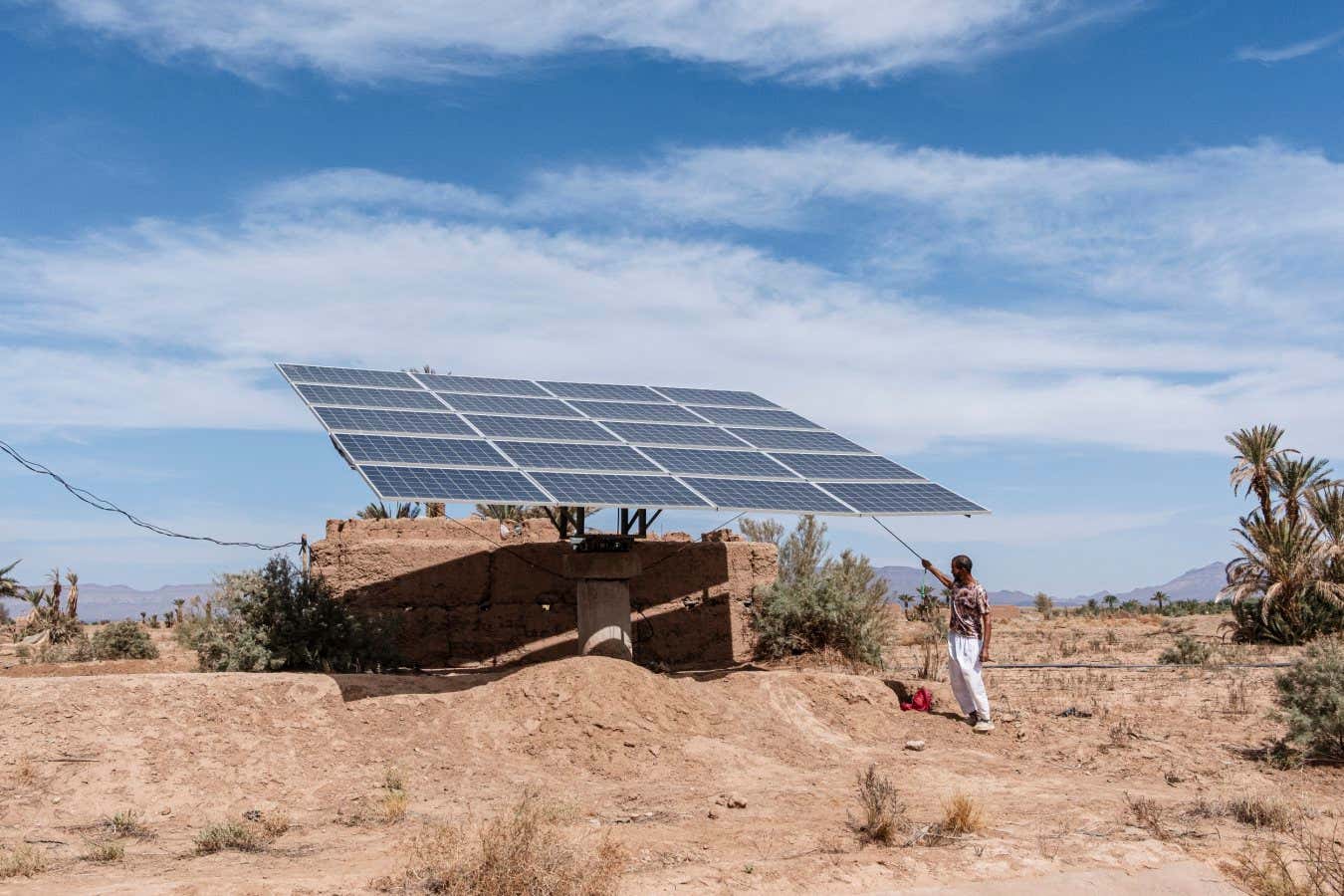 Vincenzo Montefinese - Lost Oases Tinzouline, Draa Valley, Morocco, October 2, 2023. Salim El Kabir, 42 years old, adjusts the solar panel that powers the pump for extracting water from the well used for irrigating the date palm groves near the Draa River. The increasing drought has driven farmers in the Draa River basin to dig more wells, often illegally, to access groundwater.