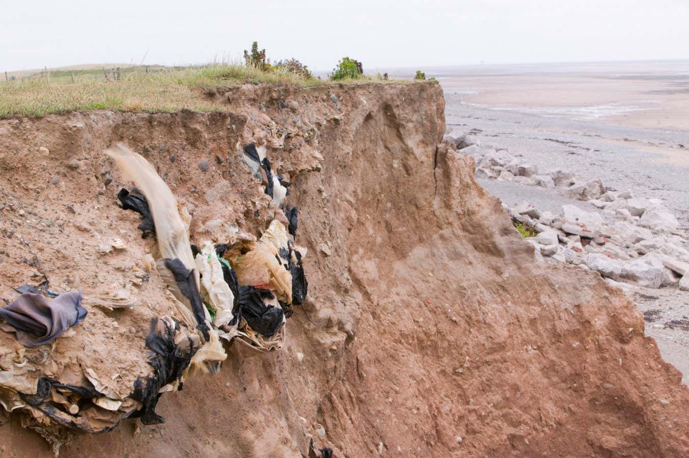 Old landfill rubbish revealed in sea cliffs by coastal erosion on Walney Island, UK