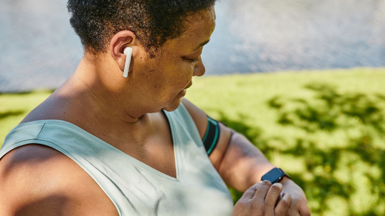 Female checks fitness app on watch during walk outside
