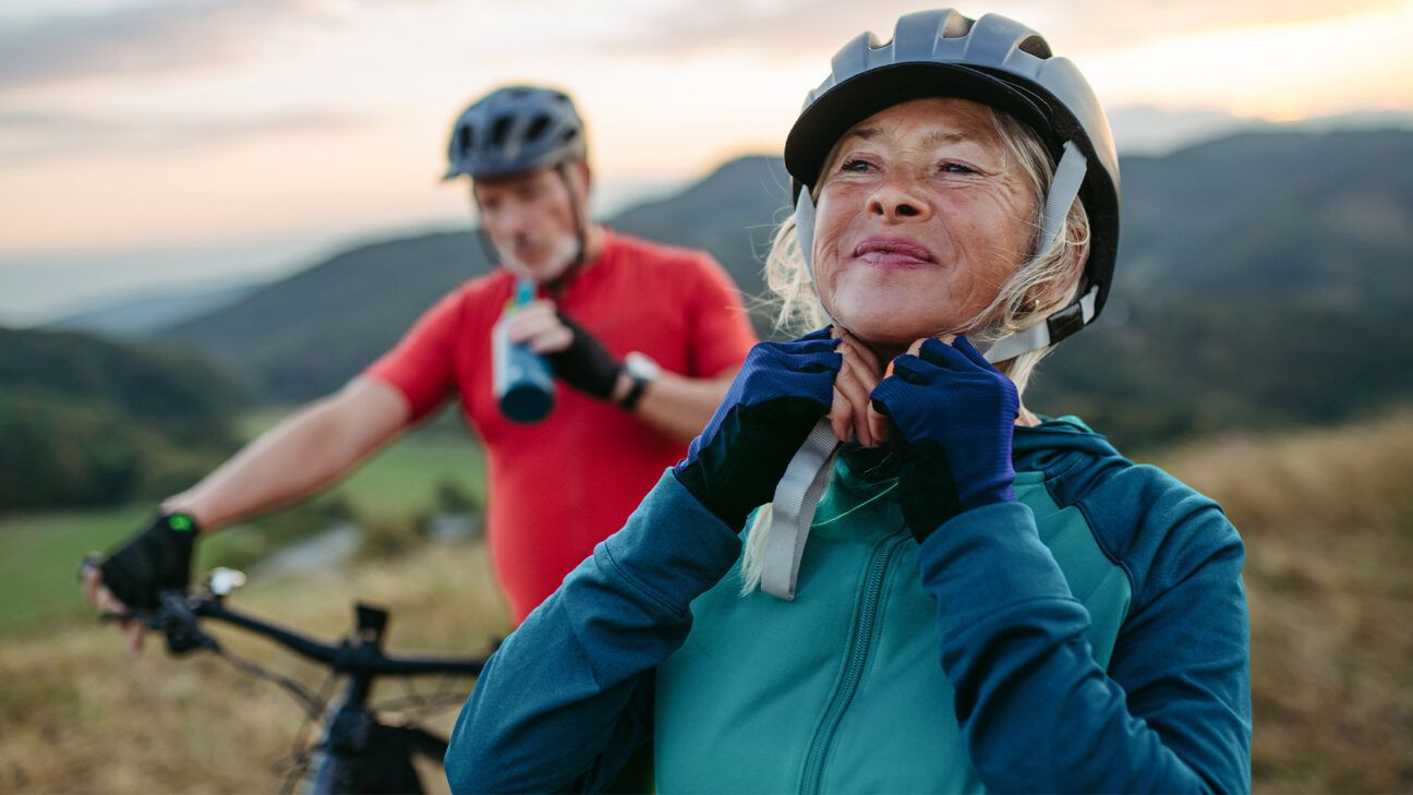 Older couple mountain biking in the mountains