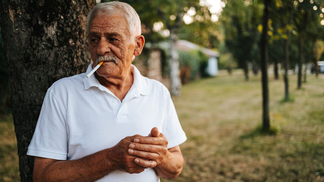 Older male smoking outside