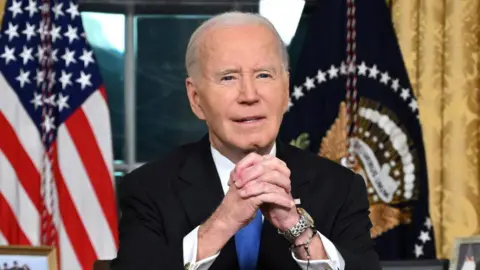 Reuters President Biden sits at his desk in the Oval Office.