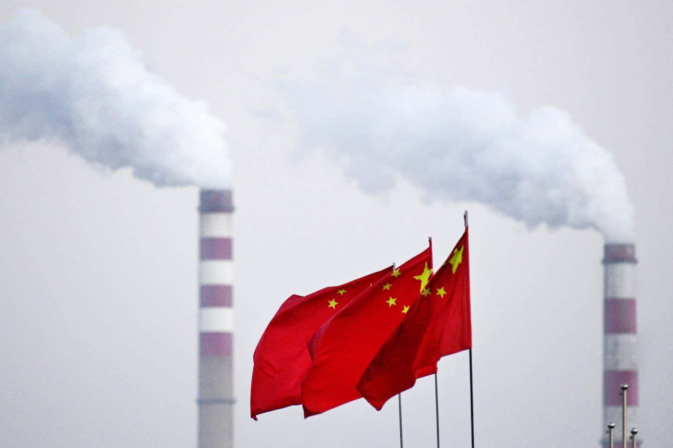 China's national flags flutter in front of a coal-powered power station in Datong, China's northern Shanxi province on November 3, 2021. (Photo by Noel Celis / AFP) (Photo by NOEL CELIS/AFP via Getty Images)