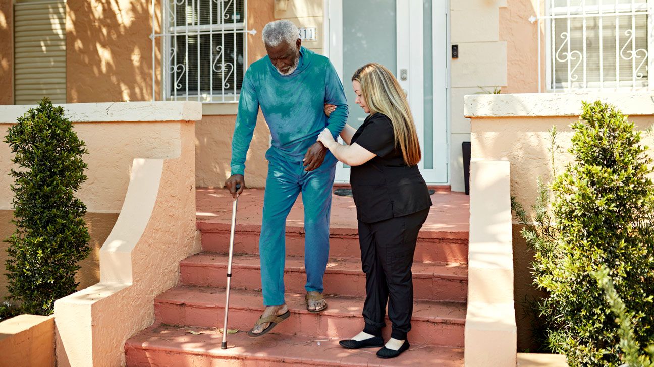 Older male gets assistance walking down steps