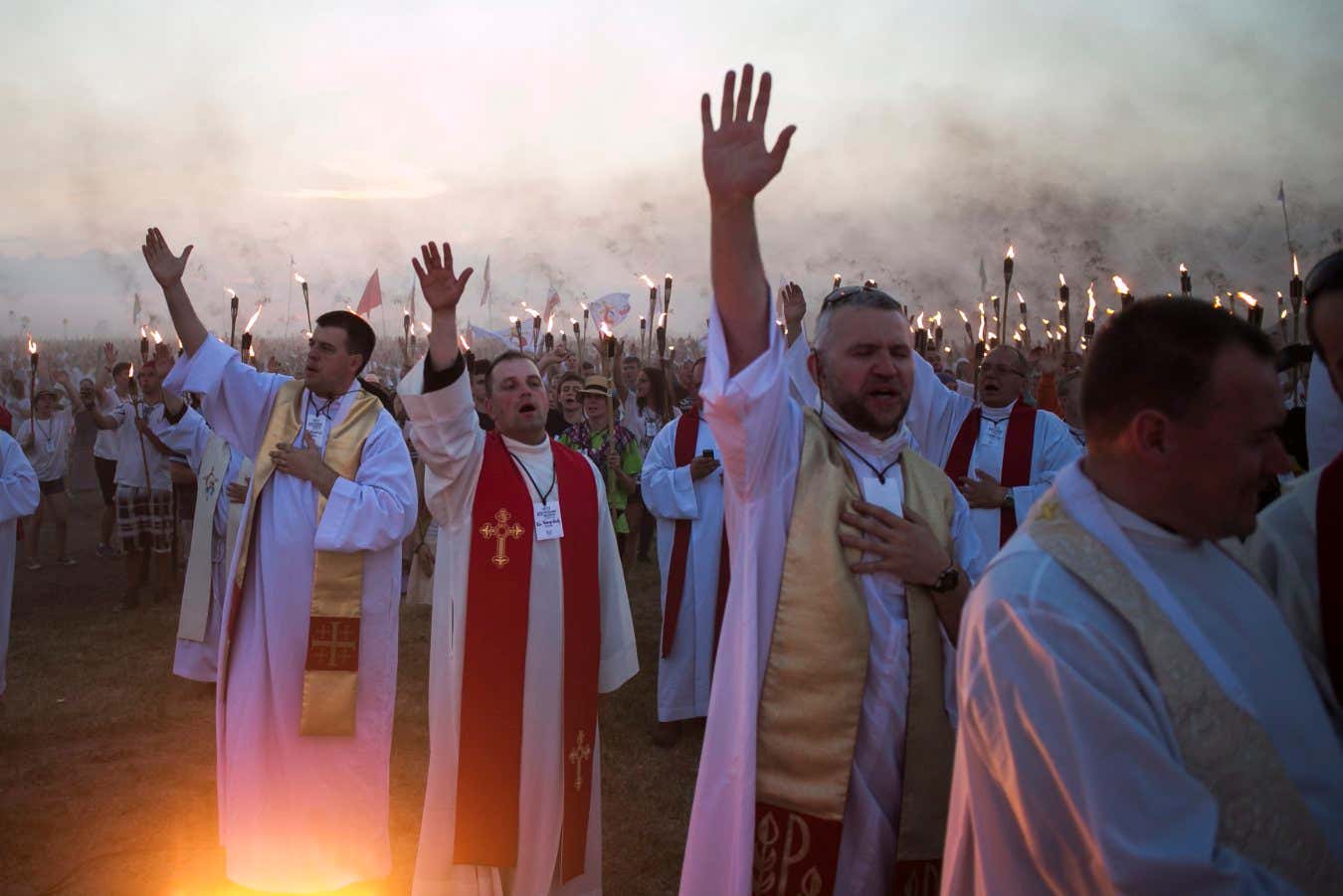 Priests praying at an annual gathering of young Polish Catholics