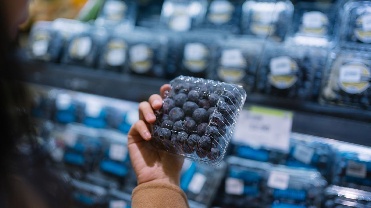 Person chooses blueberries in the supermarket