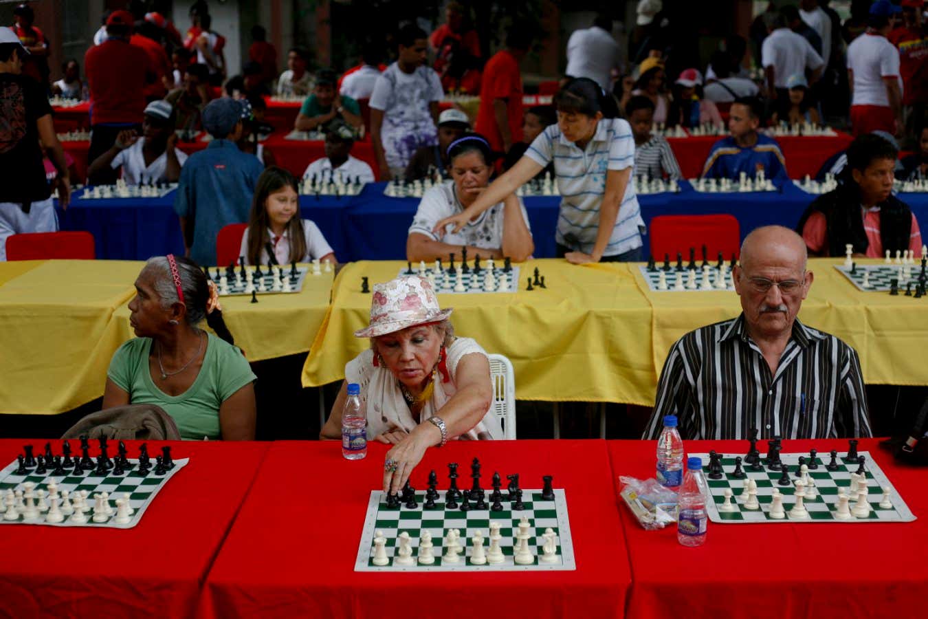People take part in a mass simultaneous chess game in Caracas August 19, 2011. Children and the elderly took part in an 800 mass simultaneous chess game organised by 