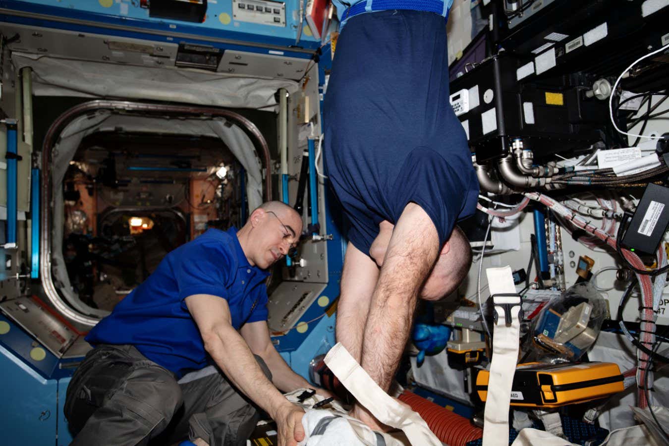 iss063e005099 (May 4, 2020) --- Roscosmos cosmonauts and Expedition 63 Flight Engineers (from left) Anatoly Ivanishin and Ivan Vagner practice chest compression techniques, or cardiopulmonary resuscitation (CPR), during an emergency training session. The crews aboard the International Space Station regularly train for a variety of emergency scenarios to stay familiar with medical hardware, safety gear and evacuation paths. Mission controllers on the ground also participate to maintain coordination and communication protocols.