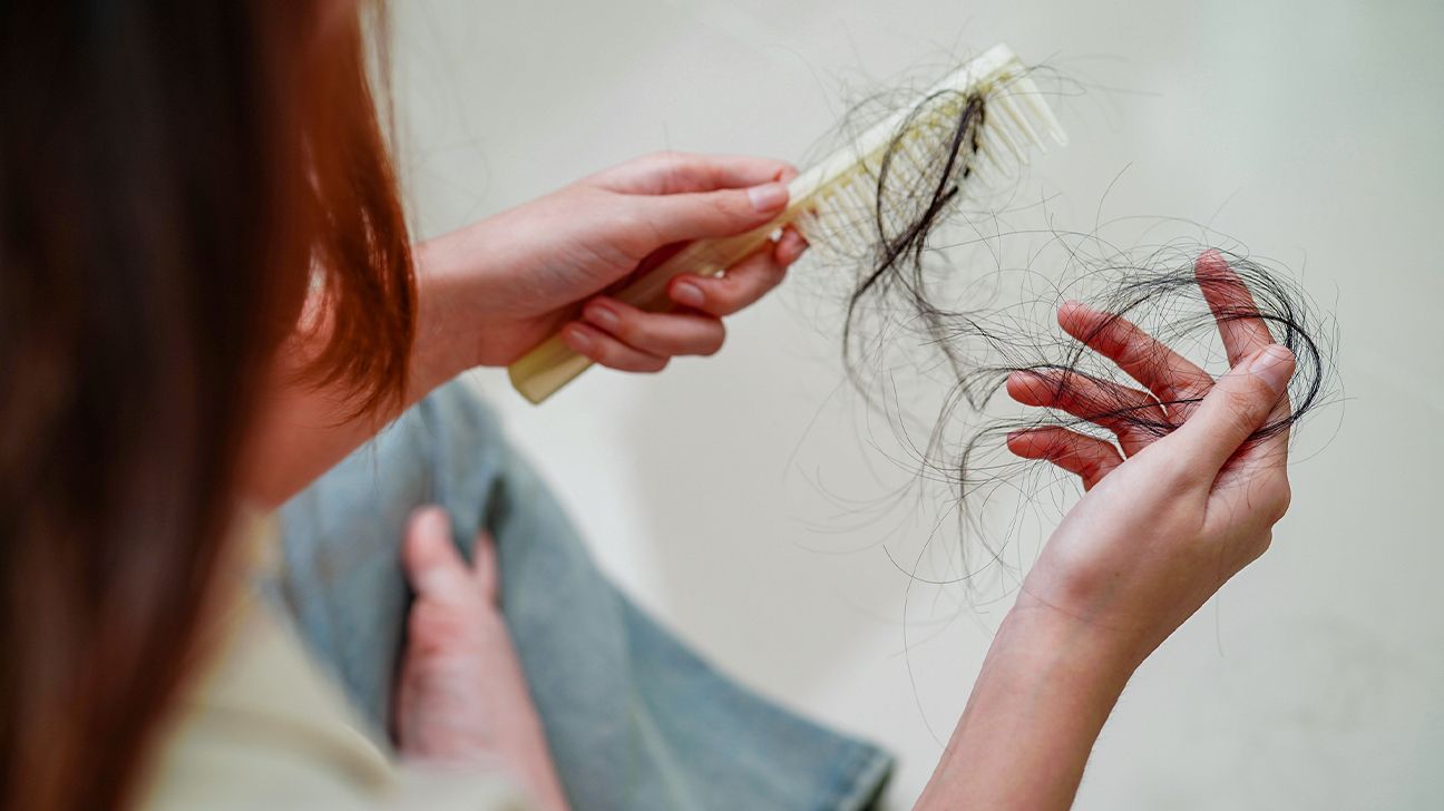 Female pulls hair out of brush