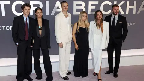 Getty Images LONDON, ENGLAND - OCTOBER 08: Cruz Beckham, Jackie Apostel, Romeo Beckham, Harper Beckham, Victoria Beckham and David Beckham attend the