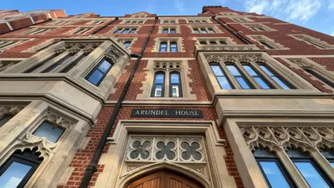 Stuart Woodward/BBC Arundel House is a red brick building with sandstone window surrounds. It is a five-storey building, with a sign reading