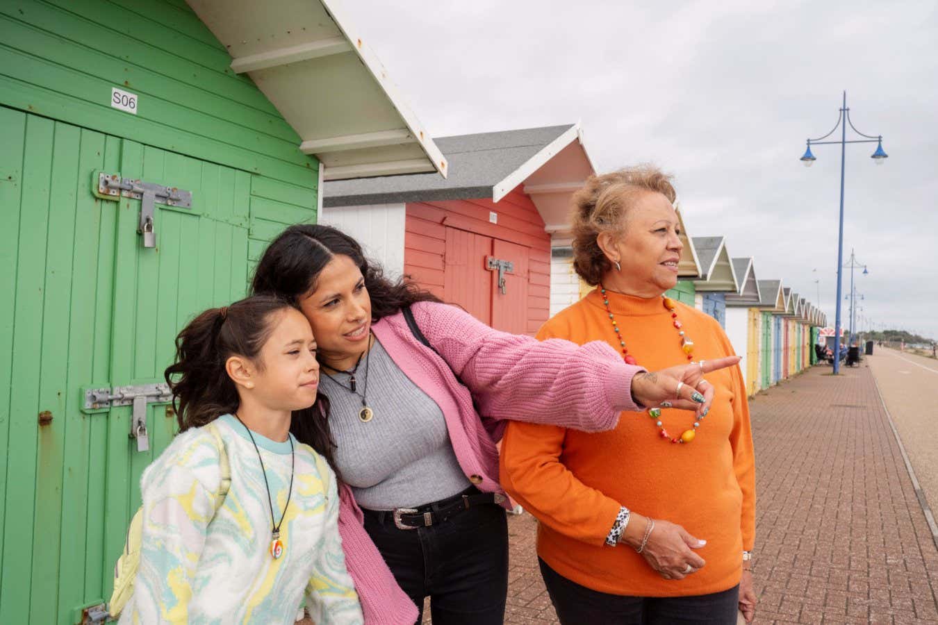 2X5TRE9 Grandmother, mother and granddaughter standing by beach hut