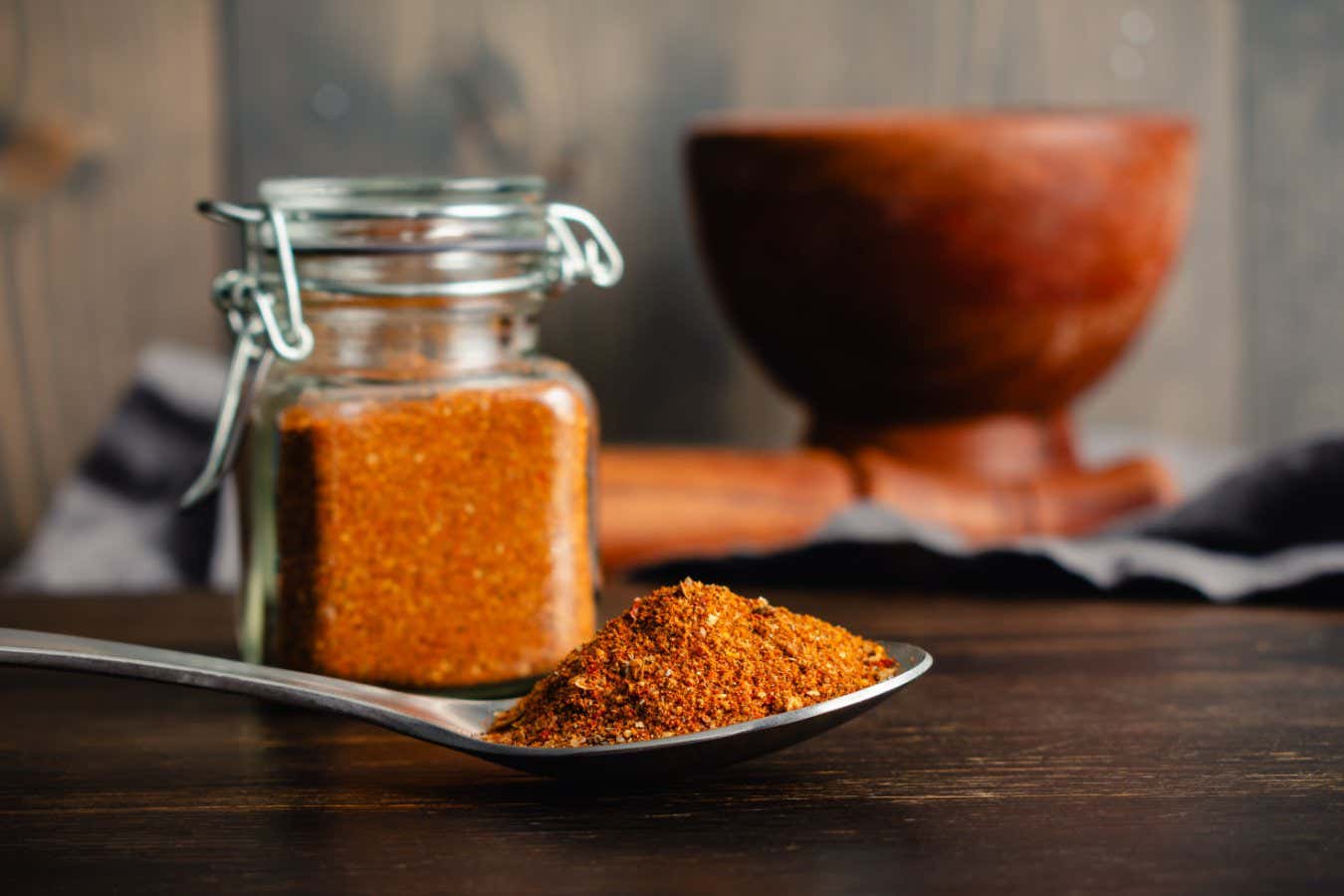 Spoonful of Homemade Berbere Spice Blend Close-up: Side view of East African spice mixture in a spoon with glass jar and mortar and pestle nearby; Shutterstock ID 2546039369; purchase_order: -; job: -; client: -; other: