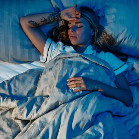 Getty Images Young woman trying to get to sleep. 