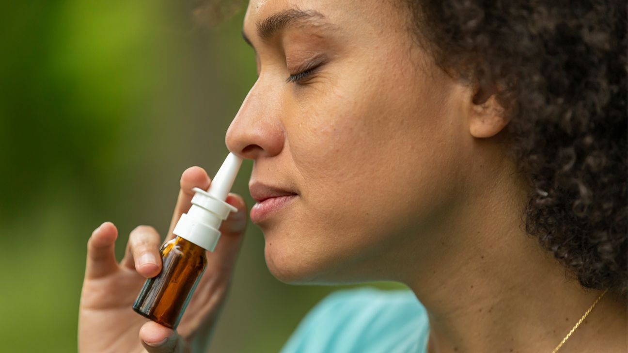 Female using nasal spray outdoors