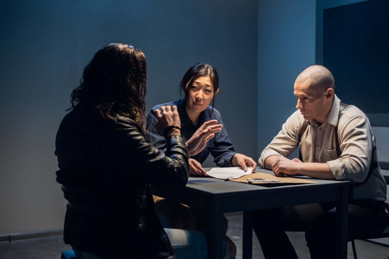 A tough police detective interrogates a crime suspect with a tattooed face in an interrogation room; Shutterstock ID 1875220249; purchase_order: -; job: -; client: -; other: