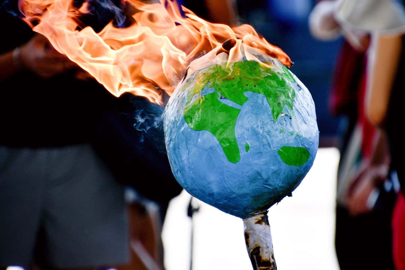 MARSEILLE, FRANCE - 2021/07/10: Protesters set a sphere representing Earth on fire during the demonstration. Members of the Extinction Rebellion group, supported by a few Yellow Vests (Gilets Jaunes in french), gathered in the Vieux-Port of Marseille to raise awareness on the dangers threatening the planet Earth. (Photo by Gerard Bottino/SOPA Images/LightRocket via Getty Images)