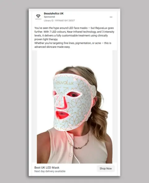 Beautaholics A social media advert showing a woman with blonde hair wearing a white LED mask with gold lines all over it and the brand Rejuvalux written across the forehead